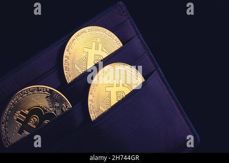 vista laterale primo piano concetto di bitcoin criptocurrency monete d'oro in cuoio nero denaro portafoglio Foto Stock