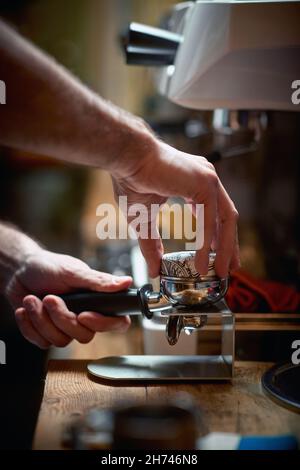 Un caffè espresso aromatico e fragrante viene preparato da un barman dietro il bar. Caffè, bevande, bar Foto Stock