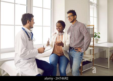 Felice coppia giovane pianificazione gravidanza e incontro con il loro medico per il controllo di salute Foto Stock
