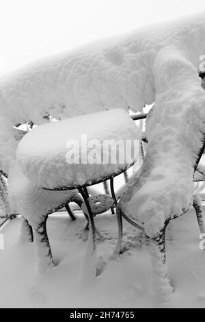 Enorme quantità di neve su mobili da giardino sulla terrazza dopo la Blizzard. Disastri naturali causati da nevicate pesanti, gelo e pioggia gelida. Foto Stock