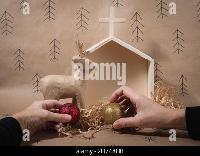 Concetto minimo eco Natale. Le mani delle donne che tengono le decorazioni fatte a mano. Preparazione per le vacanze di Natale. Foto Stock