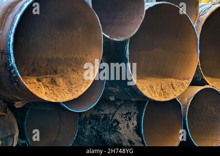 Tubi usati per la gassificazione di grande diametro giacciono nella pila. Accettazione e smaltimento di rottami metallici. Sfondo Foto Stock