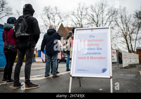 Luneburg, Germania. 20 Nov 2021. 20 novembre 2021, bassa Sassonia, Lüneburg: La gente attende in linea di fronte al centro di vaccinazione mobile. Il distretto di Lüneburg istituisce il suo centro di vaccinazione mobile a Marienplatz. Sabato scorso, la corsa è stata così enorme che tutte le riserve di vaccini sono state utilizzate. Foto: Philipp Schulze/dpa Credit: dpa Picture Alliance/Alamy Live News Foto Stock