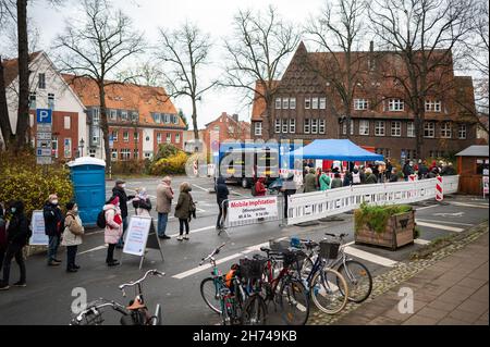 Luneburg, Germania. 20 Nov 2021. 20 novembre 2021, bassa Sassonia, Lüneburg: La gente attende in linea di fronte al centro di vaccinazione mobile. Il distretto di Lüneburg istituisce il suo centro di vaccinazione mobile a Marienplatz. Sabato scorso, la corsa è stata così enorme che tutte le riserve di vaccini sono state utilizzate. Foto: Philipp Schulze/dpa Credit: dpa Picture Alliance/Alamy Live News Foto Stock