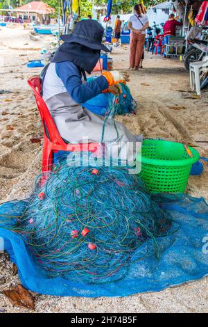 Riparazione e ispezione di una rete da pesca in spiaggia Foto Stock