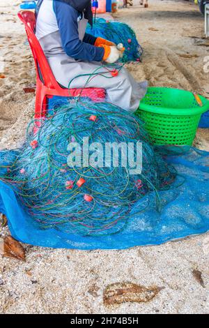 Riparazione e ispezione di una rete da pesca in spiaggia Foto Stock