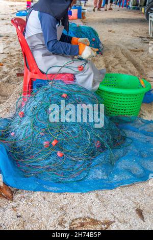 Riparazione e ispezione di una rete da pesca in spiaggia Foto Stock
