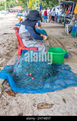 Riparazione e ispezione di una rete da pesca in spiaggia Foto Stock