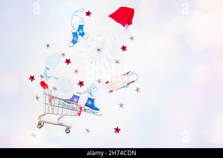 Carrello da un supermercato con regali di Capodanno e giocattoli di Capodanno su uno sfondo leggero.piatto, vista dall'alto, ampio banner.Christmas e Capodanno Foto Stock