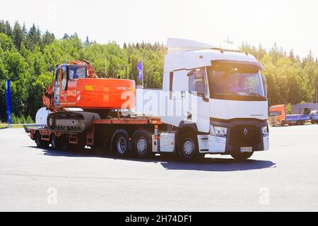 White Renault Trucks T trasporta l'escavatore cingolato Hitachi Zaxis 225 US su rimorchio con pianale di discesa, vista laterale. Forssa, Finlandia. Luglio 31, 2020. Foto Stock