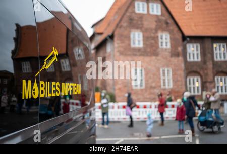 Luneburg, Germania. 20 Nov 2021. 20 novembre 2021, bassa Sassonia, Lüneburg: La gente attende in linea di fronte al centro di vaccinazione mobile. Il distretto di Lüneburg istituisce il suo centro di vaccinazione mobile a Marienplatz. Sabato scorso, la corsa è stata così enorme che tutte le riserve di vaccini sono state utilizzate. Foto: Philipp Schulze/dpa Credit: dpa Picture Alliance/Alamy Live News Foto Stock