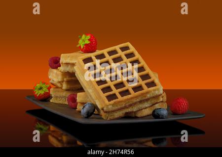 Waffle con frutta e sciroppo d'acero su sfondo colorato Foto Stock