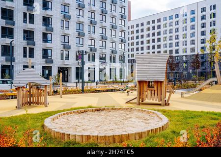 Bell'edificio multi colorato di nuova area residenziale moderna per le famiglie giovani. Parco giochi nel cortile pubblico. Quartiere residenziale con facciata a geometria luminosa. Foto Stock