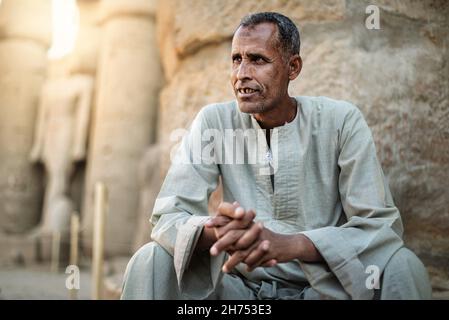 LUXOR, EGITTO - 19 ottobre 2021: Primo piano di un uomo seduto per le strade da solo guardando qualcosa di pensoso Foto Stock