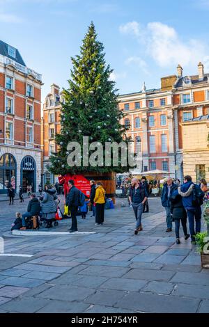 LONDRA, Regno Unito - NOVEMBRE 11 2021: Un albero di Natale gigante decorato nel Covent Garden di Londra che illumina di luci festive attrae migliaia di londinesi Foto Stock