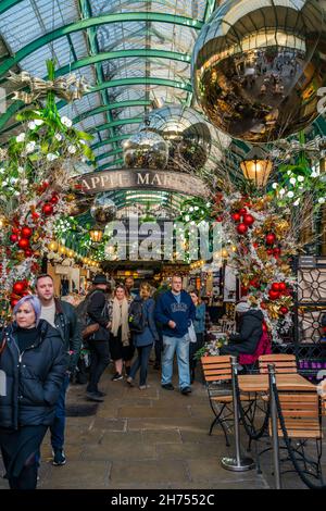 LONDRA, Regno Unito - NOVEMBRE 11 2021: I visitatori del popolare mercato Apple di Covent Garden decorati per Natale. Il mercato è un ottimo posto per trovare souvenir Foto Stock