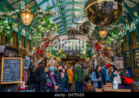 LONDRA, Regno Unito - NOVEMBRE 11 2021: I visitatori del popolare mercato Apple di Covent Garden decorati per Natale. Il mercato è un ottimo posto per trovare souvenir Foto Stock