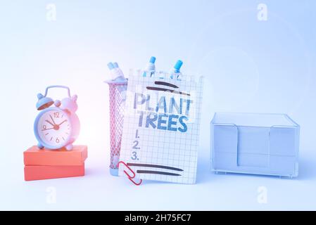Scrittura visualizzazione di alberi di piante di testo. Parola scritta sul processo di piantare un albero per coltivazione di terra e silvicoltura Tidy Workspace Setup scrivania Foto Stock