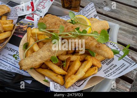 10 ottobre 2021 - Hundested, Danimarca: Un piatto di deliziosi fish and chips. Business come al solito nei ristoranti nel porto turistico Foto Stock