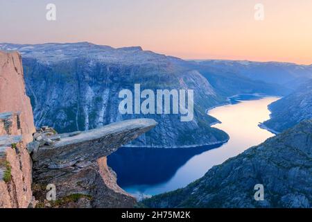 Tramonto a Trolltunga - famoso punto di riferimento in Norvegia. Vista panoramica del lago fiordo e delle montagne, paesaggio estivo Foto Stock