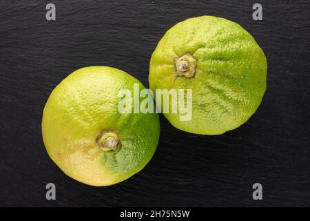 Due bergamotti biologici succosi su una pietra ardesia, primo piano, vista dall'alto. Foto Stock