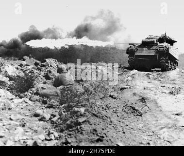 IWO JIMA, OCEANO PACIFICO - Marzo 1945 - Un carro armato di lancio della fiamma Marina, noto anche come 'Ronson', scorga un punto di forza giapponese. L'otto M4A3 Sherman Foto Stock