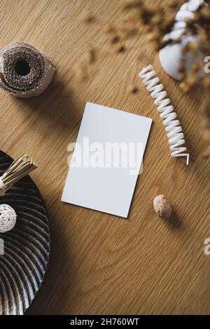 Mockup di invito di nozze, vaso di fiori secchi e decorazioni autunnali su tavola di legno. Disposizione piatta, vista dall'alto, spazio di copia Foto Stock