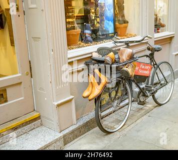 Cambridge, Cambridgeshire, Regno Unito – Novembre 16 2021. La bicicletta è utilizzata come un'area pubblicitaria all'esterno del negozio di scarpe Loake fatto a mano nel centro della città Foto Stock
