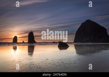 Tramonto e riflesso del fiasche a Cannon Beach Foto Stock