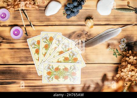 Carte Tarot fanned faccia in giù su superficie di legno con pietre, piante autunnali e accessori. Vista dall'alto. Minsk, Bielorussia, 11.10.2021 Foto Stock