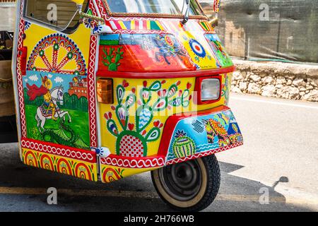 Apecar o macchina a tre ruote meravigliosamente decorata con motivi tipici siciliani. Primo piano catturato nelle strade di Taormina in una giornata di sole, Sicilia, Ital Foto Stock