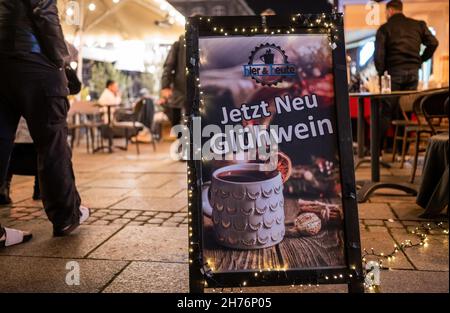 20 novembre 2021, bassa Sassonia, Lüneburg: "Ora VIN brulé" è scritto su un cartello non lontano dal mercato di Natale sulla piazza del municipio. L'odore di bratwurst e mandorle dovrebbe attirare i visitatori nella città vecchia di Lüneburg da mercoledì (24 novembre) in poi. Allestendo le bancarelle, la città anseatica vuole implementare il concetto di Lüneburg come città di Natale. Deve essere applicata la regola 2G. Foto: Philipp Schulze/dpa Foto Stock