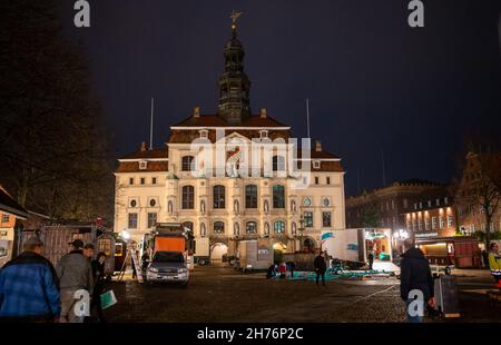 20 novembre 2021, bassa Sassonia, Lüneburg: Showmen ha istituito il mercato di Natale sulla piazza del municipio. L'odore di bratwurst e mandorle dovrebbe attirare i visitatori nella città vecchia di Lüneburg da mercoledì (24 novembre) in poi. Con la costruzione delle bancarelle, la città anseatica vuole implementare il concetto di città di Natale di Lüneburg. Deve essere applicata la regola 2G. Foto: Philipp Schulze/dpa Foto Stock