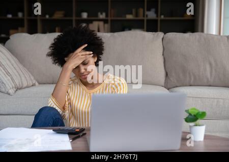 Frustrato giovane donna nera del proprietario di abitazione che ottiene il email con le notizie difettose Foto Stock