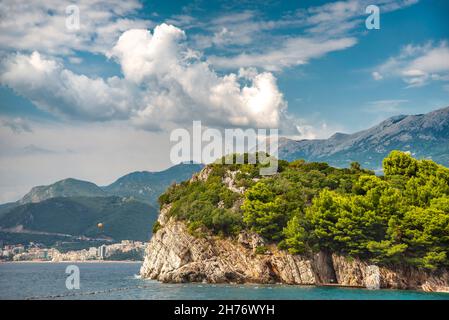 Bei sentieri alberati che corrono a nord da Sveti Stefan Island, oltre il mare blu e le località turistiche, punteggiato lungo la costa adriatica. Foto Stock