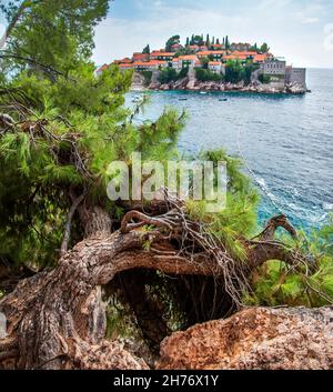 Un isolotto esclusivo, privato e idilliaco, chiamato un hotel-villaggio, che si snoda nel mare visto da un sentiero panoramico che si snoda lungo un tratto boscoso roccioso di Foto Stock