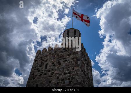 Castello medievale di Rabati con una bandiera georgiana svolazzante contro il cielo nuvoloso blu. Akhaltsikhe, Georgia. Foto Stock