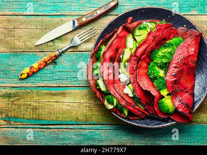 Frittelle di barbabietole farcite di verdure. Cibo sano, cibo dietetico. Flapjack di verdure Foto Stock