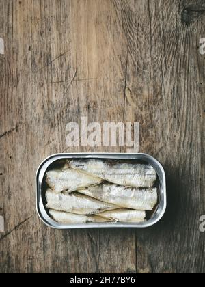 le sardine aperte possono su vecchio tavolo da cucina in legno, vista dall'alto Foto Stock
