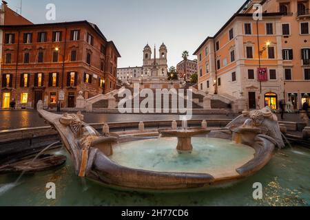 Piazza di Spagna e Fontana di Barcaccia al tramonto nella città di Roma, Italia. Foto Stock