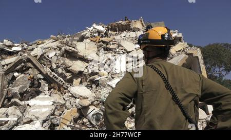 I soldati israeliani dell'unità di salvataggio del comando Home Front camminano attraverso le macerie di un edificio collassato mentre prendono parte a un trivello di ricerca e salvataggio in un grande sito di demolizione il 16 novembre 2021 a Tel Aviv, Israele. Il trapano Home Front simula l'operazione di ricerca e salvataggio preparando scenari che potrebbero distruggere edifici e intrappolare i cittadini a causa di un terremoto importante o massicce barrature di razzi. Foto Stock