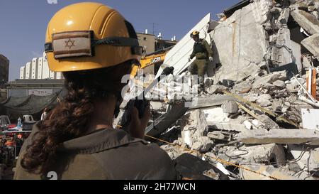 I soldati israeliani dell'unità di salvataggio del comando Home Front camminano attraverso le macerie di un edificio collassato mentre prendono parte a un trivello di ricerca e salvataggio in un grande sito di demolizione il 16 novembre 2021 a Tel Aviv, Israele. Il trapano Home Front simula l'operazione di ricerca e salvataggio preparando scenari che potrebbero distruggere edifici e intrappolare i cittadini a causa di un terremoto importante o massicce barrature di razzi. Foto Stock