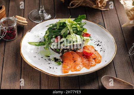 Piatto di salmone affettato salato e insalata verde Foto Stock