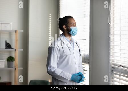 Uomo medico africano americano pensivo indossare maschera medica pensiero Foto Stock