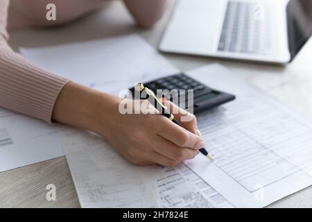 Primo piano donna che riempie documenti finanziari, calcolando fatture o tasse Foto Stock