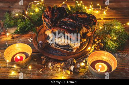 Impasto arricchito arrotolato con il tradizionale ripieno di semi di papavero spalmato. Babka sullo sfondo di Natale Foto Stock