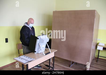 Sofia, Bulgaria. 21 Nov 2021. Un elettore utilizza una macchina di voto elettronica per votare durante il secondo turno delle elezioni presidenziali in un seggio elettorale a Sofia, Bulgaria, 21 novembre 2021. I bulgari si sono recati alle urne domenica mattina per votare nel secondo turno delle elezioni presidenziali. Quasi 6.7 milioni di elettori aventi diritto sceglieranno il loro presidente per i prossimi cinque anni tra il presidente in carica Rumen Radev e il rettore dell'Università di Sofia Anastas Gerdjikov. Credit: Marian Draganov/Xinhua/Alamy Live News Foto Stock