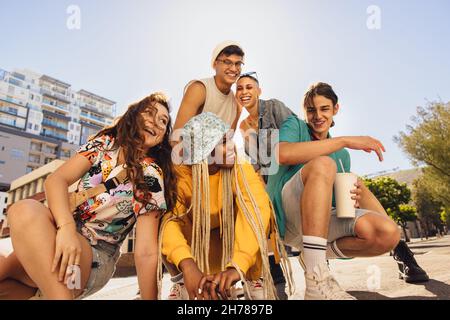 Amici sorridenti che si divertono all'aperto. Gruppo di amici multietnici di generazione z che si divertono a trascorrere il tempo insieme. Amici giovani allegri che mi fanno felice Foto Stock