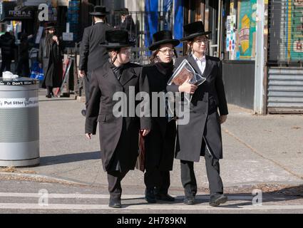 3 ragazzi ebrei ortodossi, probabilmente adolescenti, vestiti in modo molto simile camminano su Lee Avenue il venerdì pomeriggio. A Williamsburg, Brooklyn, New York. Foto Stock