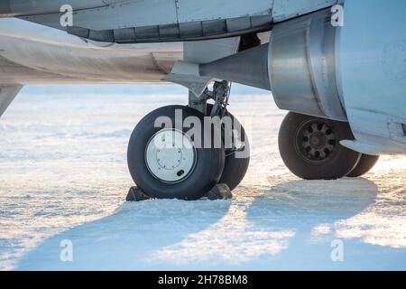 telaio aereo close-up in inverno nella neve. Primo piano del telaio dell'aereo di linea passeggeri nella neve sulla piattaforma dell'aeroporto. Foto Stock